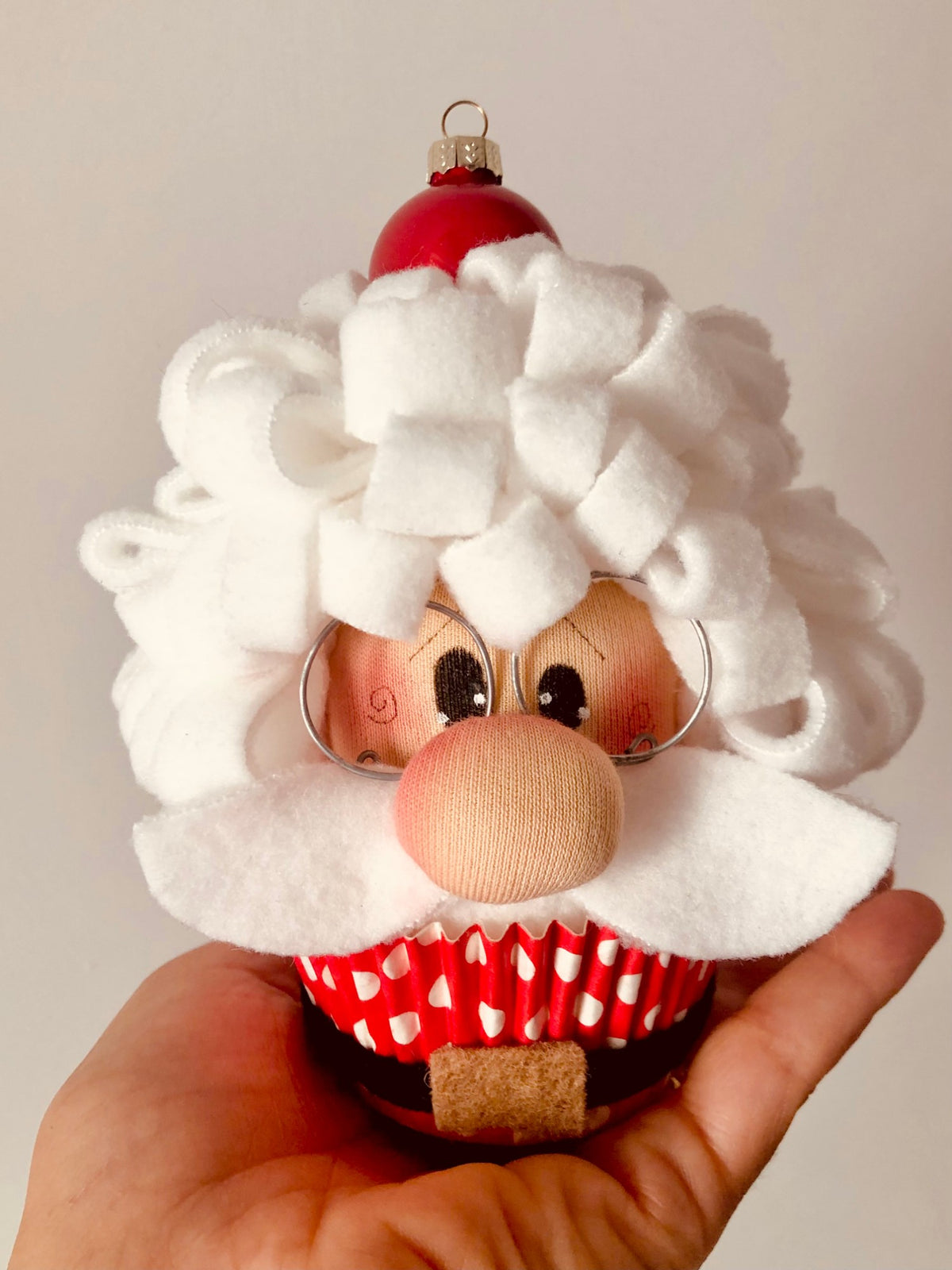Santa Muffin finito in mano: Babbo Natale di micro pile e pannolenci a forma di muffin, alto 15 cm